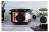 A rose gold slow cooker is displayed on a table with a brick wall in the background. Náhled obrázku produktu