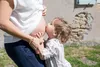 A child kisses a pregnant woman's belly. Produktbild-Vorschau