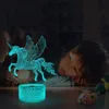 A child is lying on a table, looking at a glowing unicorn lamp. Produktbild-Vorschau