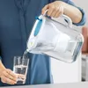 A person pouring filtered water from a pitcher into a glass. Náhled obrázku produktu