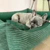 A French Bulldog is sleeping in a green corduroy dog bed. Náhled obrázku produktu