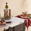 An outdoor serving cart with various food items and kitchen accessories. Produktbild-Vorschau