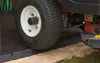 A close-up view of a lawnmower tire on a black ramp. Náhľad obrázku produktu