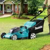 A person is mowing a lawn with a Makita cordless lawnmower in front of a house. Náhled obrázku produktu