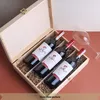 A wooden box containing three bottles of red wine, with a wine glass to the side. Produktbild-Vorschau