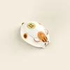 A cute, cartoonish computer mouse designed to look like a cat or hamster, resting on a plain, light-colored surface. Náhled obrázku produktu