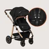 A black and gold stroller with a close-up inset showing the harness system. Produktbild-Vorschau