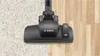 A vacuum cleaner head is shown cleaning both carpet and hardwood floors. Produktbild-Vorschau