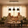 A family is sitting on a couch, wrapped in blankets, and laughing. There is a coffee table in front of them with drinks and snacks. Náhled obrázku produktu