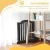 A black pet gate is shown in a room with sheer curtains and a wooden shelf unit. Anteprima dell’immagine prodotto