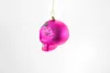 A pink skull-shaped Christmas ornament hangs from a gold string against a white background. Produktbild-Vorschau