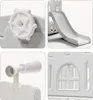 Collage of close-up shots of a white plastic playground structure, showing details like a steering wheel, a slide, a telescope-like accessory, and a window. Náhľad obrázku produktu