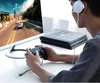 A person playing a video game with headphones on, holding a controller, with a gaming console and monitor in front of them. Anteprima dell’immagine prodotto