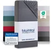 A stack of folded fitted sheets in various colors, with a close-up of one gray sheet in the foreground. Voir les images du produit