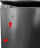 A close-up of a brushed metal surface, possibly a refrigerator door, with two red arrows pointing to subtle dents or imperfections. Produktbild-Vorschau