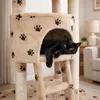 A black cat is resting inside a cat tree with paw print patterns. Náhľad obrázku produktu