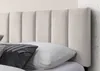 A close-up of a beige upholstered headboard with vertical channels, with pillows in front of it. Náhľad obrázku produktu
