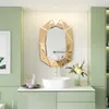 A modern bathroom vanity with a sink, mirror, and decorative items. Produktbild-Vorschau