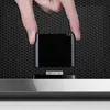 A hand is inserting a black adapter into a device. Produktbild-Vorschau