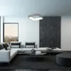 A modern living room with a sectional sofa, coffee table, and a large window overlooking a city. Náhled obrázku produktu
