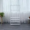 A white garment rack with multiple shelves and hooks stands against a white curtain. Anteprima dell’immagine prodotto