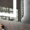 Close-up of a modern illuminated mirror with LED lights on the side, reflecting a room interior. Podgląd zdjęcia produktu