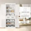 A white storage cabinet with its doors open, showcasing its interior shelves and drawers. The cabinet is placed in a room with dining furniture in the background. Produktbild-Vorschau