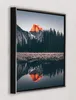 A framed picture of Half Dome in Yosemite National Park at sunset, reflected in a body of water. Produktbild-Vorschau
