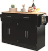 A black kitchen island with a wooden countertop is shown against a white background. The island has two drawers and four cabinet doors, with silver handles. A side rack holds utensils. The countertop is decorated with a plant, utensils, a jar, fruit, a win Voir les images du produit