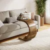 A C-shaped side table is placed next to a sofa in a living room setting. Anteprima dell’immagine prodotto