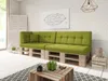 A modern living room with a green pallet sofa, a wooden coffee table, and a white brick wall. Produktbild-Vorschau
