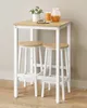 A small bar table with two stools, a plant, and drinks on top. Produktbild-Vorschau