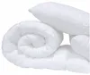 A white duvet and two white pillows are rolled and stacked on a white background. Podgląd zdjęcia produktu
