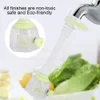 A faucet extender is shown attached to a faucet, with a close-up inset of the extender's head. In the background, fresh produce like lettuce and lemons are visible, suggesting kitchen use. Produktbild-Vorschau