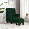 A dark green massage chair and ottoman are shown in a well-lit room with a plant and a window. Náhled obrázku produktu