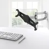 A tablet wall mount is shown attached to a wall above a desk with a keyboard and pen. Podgląd zdjęcia produktu