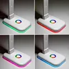 A collage of four images showing a white LED desk lamp with different colored RGB base lights. Produktbild-Vorschau