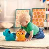 A baby playing with two plush toys on a rug. Náhled obrázku produktu