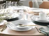 A table setting with plates, bowls, cups, and cutlery. Produktbild-Vorschau