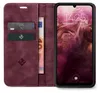 A burgundy flip case for a smartphone is open, revealing card slots and a banknote. The smartphone screen displays the time and date. Produktbild-Vorschau