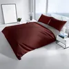 A bedroom scene with a bed made with bordeaux and anthracite bedding, next to a window. Produktbild-Vorschau