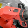 A close-up view of the handle and controls of a red and black power tool, likely a saw. Produktbild-Vorschau