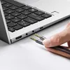 A hand is holding two 3.5mm audio splitter cables near the ports of a laptop. Podgląd zdjęcia produktu