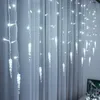 Icicle-shaped LED lights hanging in front of a white curtain. Produktbild-Vorschau