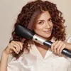 A woman with curly hair is using a hair styling tool. Produktbild-Vorschau