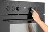 A hand is shown adjusting a knob on a black oven control panel. Produktbild-Vorschau