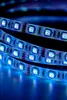 A close-up, coiled view of a blue LED strip light against a dark background. Podgląd zdjęcia produktu