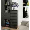 A gray dresser with six drawers stands next to a bookshelf filled with books and decorative items. Two abstract paintings hang on the wall behind the dresser, and a portion of a gray sofa is visible in the foreground. Voir les images du produit