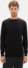 A man wearing a black long-sleeved sweater. Produktbild-Vorschau