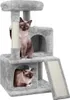 Two cats are on a multi-level cat tree with scratching posts and hideaways.